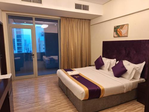a bedroom with a large bed with purple pillows at Aspire Tower in Manama