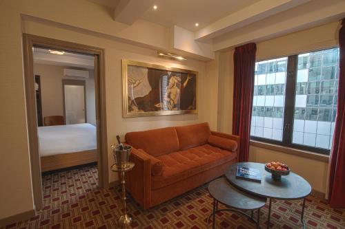 a living room with a couch and a table and a bed at Hotel Edison Times Square in New York