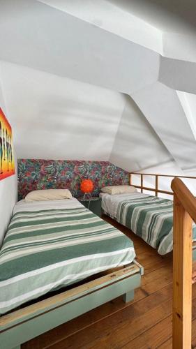 two beds in a room with a white ceiling at Holiday Properties, Ilha do Fogo in Santa Maria