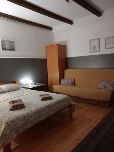a hotel room with two beds and a couch at Studio apartmani Tanja in Bela Crkva