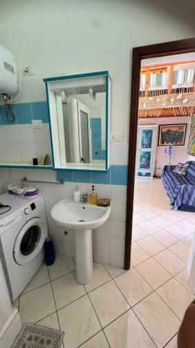 a bathroom with a sink and a washing machine at Holiday Properties, Ilha do Fogo in Santa Maria