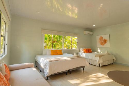 a bedroom with two beds and a window at Selvática Residences in Puerto Viejo
