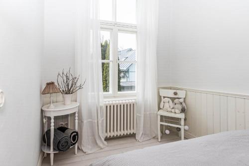 a bedroom with a bed and a window with curtains at Linda Külaliskorter in Haapsalu