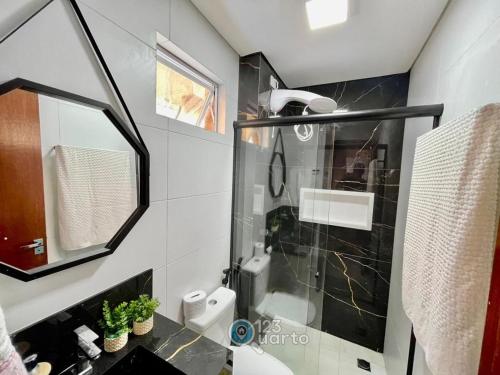 a bathroom with a glass shower stall and a toilet at Samburá Residece By 123Quarto in Camalaú