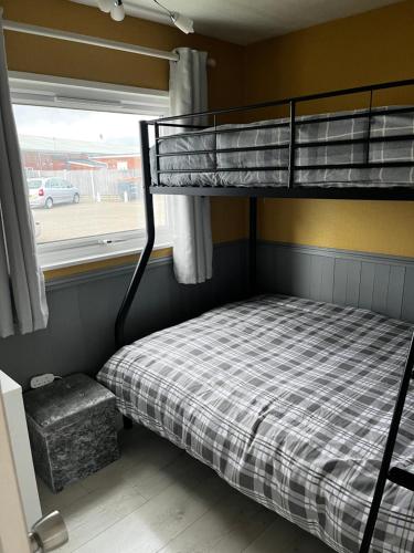 a bunk bed in a room with a window at JJ chalet in Scratby