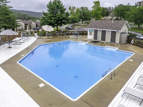 a large blue swimming pool in front of a house at Lantern Bay Retreat in Branson