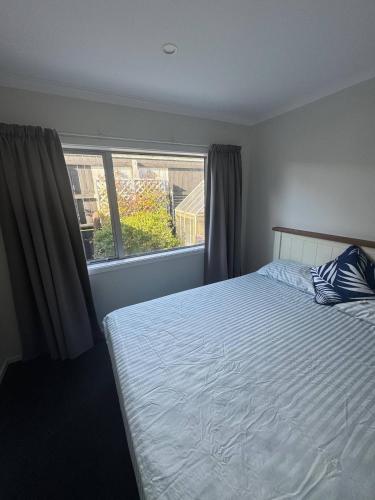 a bedroom with a bed and a window at Spacious One-Bedroom with Private Bathroom Aotea in Porirua