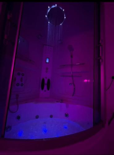 a purple bathroom with a tub in a room at Safety house in Tabuk