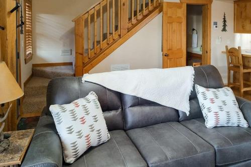a leather couch with two pillows on top of it at Beautiful Branson in Branson West