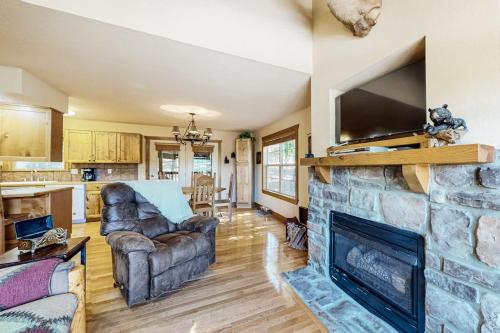 a living room with a stone fireplace with a flat screen tv at Beautiful Branson in Branson West