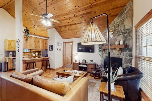 a living room with a couch and a stone fireplace at Woodland in Branson West