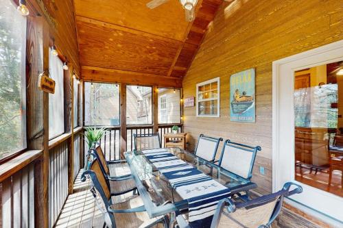 a dining room with a table and chairs on a porch at Woodland in Branson West