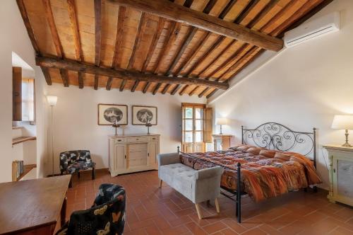 a bedroom with a large bed and a wooden ceiling at Fattoria La Striscia in Gambassi Terme