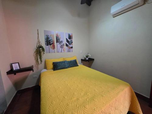 a bedroom with a bed with a yellow bedspread at Hotel Casona Macondo, Granada, Nicaragua in Granada