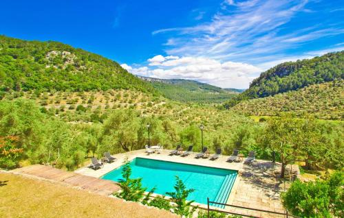 a swimming pool with chairs and a view of a mountain at Biniforani Nou in Bunyola
