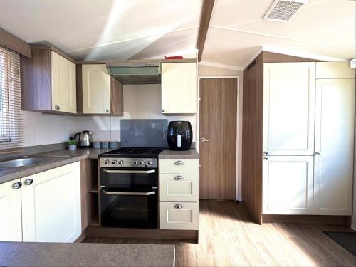 a kitchen with white cabinets and a stove top oven at Primrose View in Filey