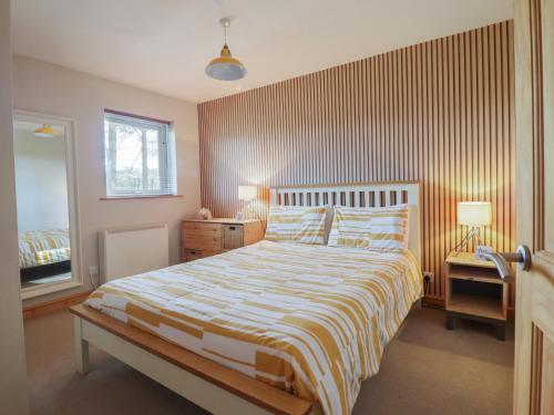 a bedroom with a bed with a striped bedspread at Redwood in Harlech