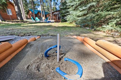 a pile of wooden sticks in the sand in a yard at Glacier Cabins in Martin City