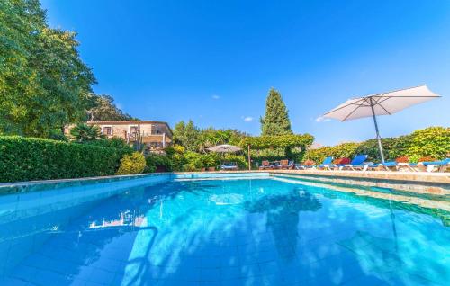 a swimming pool with an umbrella and chairs at Ca Les Estamenyes in Pollença