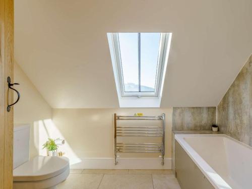 a bathroom with a toilet and a tub and a window at 3 Bed in Crickhowell oc-90757 in Cwm-du