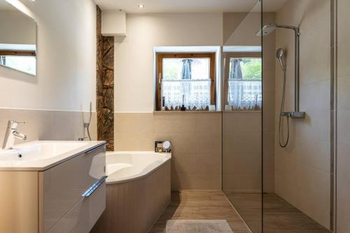 a bathroom with a tub and a sink and a shower at 100 m2 Familien 4-Zimmer Apartment mit Terrasse und Burgblick und gratis parken in Maria Enzersdorf