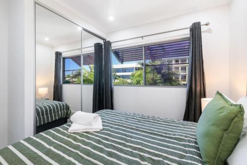 a bedroom with a bed and a large window at Perfect in Parap in Paraparap