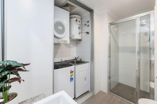 a small bathroom with a sink and a shower at Perfect in Parap in Paraparap