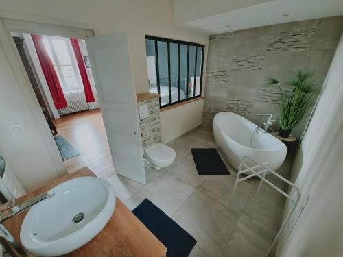 a bathroom with a white tub and a sink at Gîte De Charme - La Mésangerie in Saint-Satur