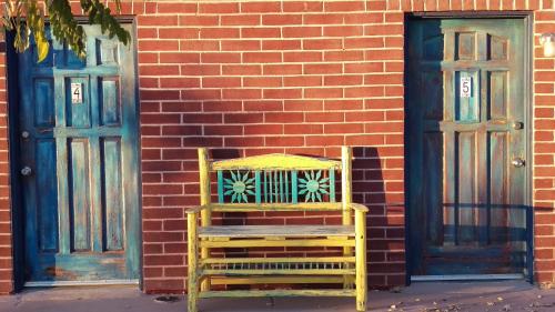 a yellow chair sitting in front of two doors at Rocket Inn in Truth or Consequences