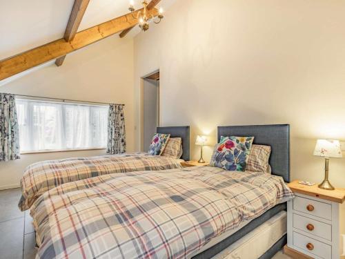 a bedroom with two beds and a window at 2 Bed in Bideford oc-60765 in Buckland Brewer