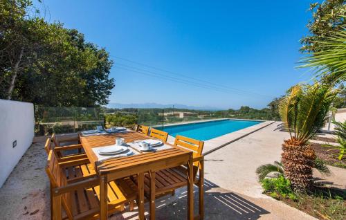 a wooden table and chairs next to a swimming pool at Mater Randa in Algaida