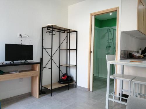 a room with a tv and a shelf with a television at L'escale in Mers-les-Bains