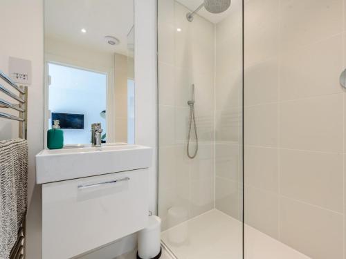 a white bathroom with a shower and a sink at 1 Bed in Manningtree oc-78389 in Lawford