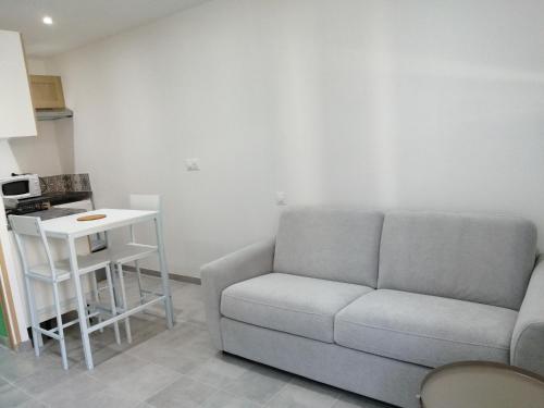 a living room with a couch and a table at L'escale in Mers-les-Bains