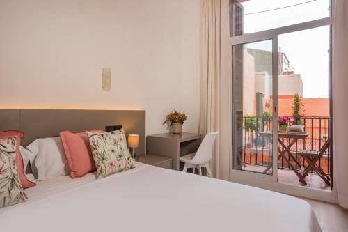 a bedroom with a large bed and a balcony at Antonios Hostal in Sitges
