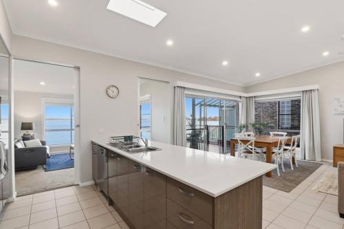 a kitchen and living room with a view of the ocean at Scenic Shores in Budgewoi