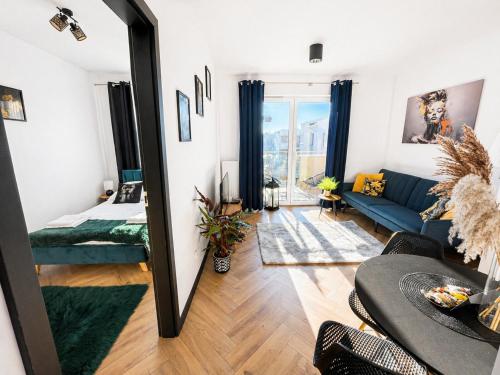 a living room with a mirror and a blue couch at Ami Luxury Residence XII CENTRUM - parking in Iława