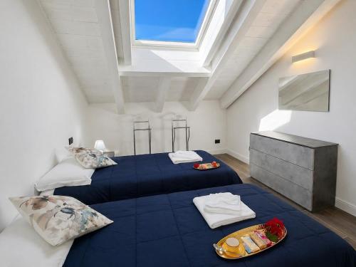 a attic bedroom with two beds and a window at Apt. Aries - Penthouse Menaggio in Menaggio