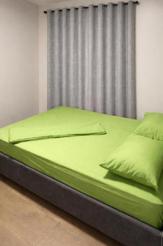 a large bed with green sheets in a bedroom at Southgate Residence in Paramaribo