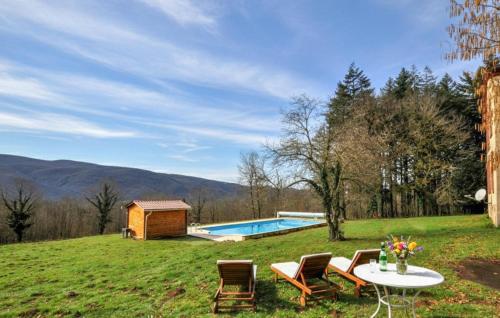 a backyard with a table and chairs and a pool at Authentique Maison Piscine in Saint-Amans-Valtoret