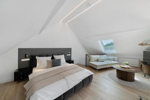 a bedroom with a large bed and a couch at Kaisers Anwesen in Vogtsburg