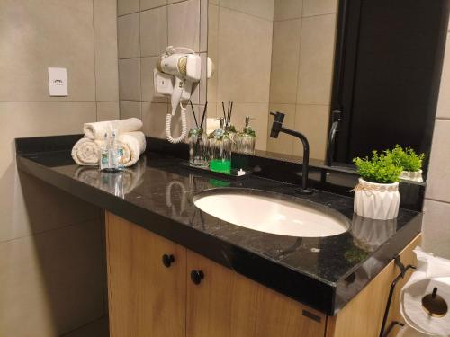 a bathroom counter with a sink and a mirror at One Studios Indaiatuba in Indaiatuba