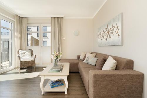 a living room with a couch and a table at Haus Vogelflug strandleev3 in Fehmarnsund