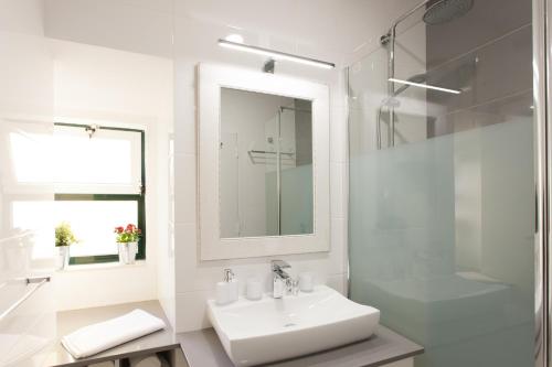 a white bathroom with a sink and a shower at White Tiles in City Center in Lisbon