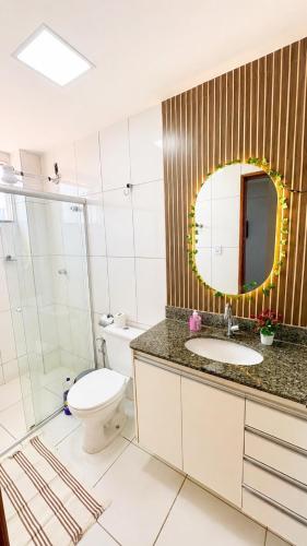 a bathroom with a toilet and a sink and a mirror at Studio Moderno e Aconchegante , Centro Unai in Unaí