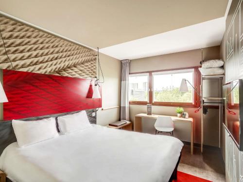 a bedroom with a white bed and a red headboard at ibis Paris Bercy Village in Paris