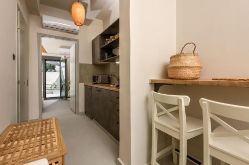 a kitchen with two white chairs and a counter at The Old Port in Limenas
