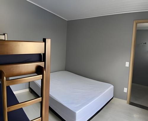 a small room with a bed and a chair at Casa do Bruno, 600 mt do thermas in Olímpia