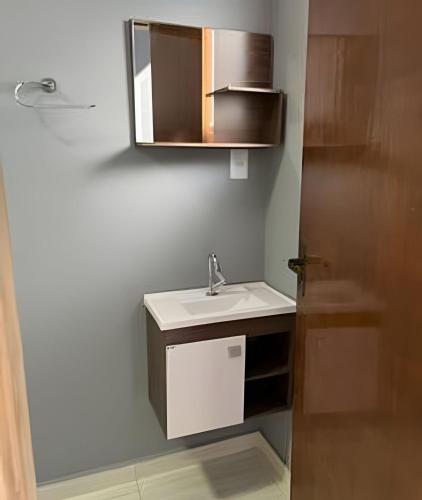 a bathroom with a sink and a mirror at Casa do Bruno, 600 mt do thermas in Olímpia