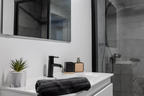 a bathroom with a sink and a mirror and a shower at Azor Signature Flats - III in Ponta Delgada